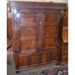 A 17th century joined oak press cupboard with a scroll carved frieze and panelled doors, 142cm by