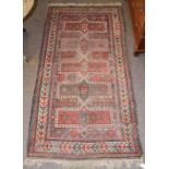 Karabagh rug, the field with a columm of heraldic panels enclosed by parasol motif borders, 240cm by