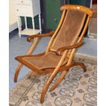 A walnut framed and cane seated folding steamer chair Canework in good order. Frame with a few