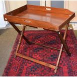 An early 19th century mahogany butlers tray with folding oak stand