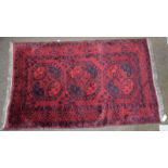 Afghan Turkmen rug, the claret field with three elephant foot güls enclosed by triple borders, 180cm