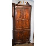 A George III mahogany standing corner cupboard with swan neck pediment, with panelled doors and bone
