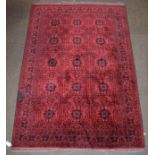 Afghan Turkman rug, the blood red field with three columns of medallions enclosed by reciprocal