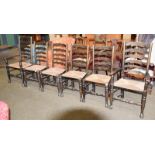 A set of six 20th century oak and rush seated ladderback dining chairs, including a pair of carver