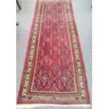 Hamadan runner, the crimson Herati field enclosed by carnation borders, 193cm by 75cm, together with