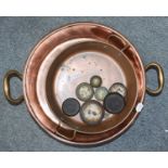 A 19th century shallow copper cooking pot with twin brass handles, inscribed W. 5, together with a