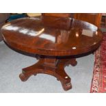 William IV rosewood loo table raised on a square tapering pedestal over four carved scrolling