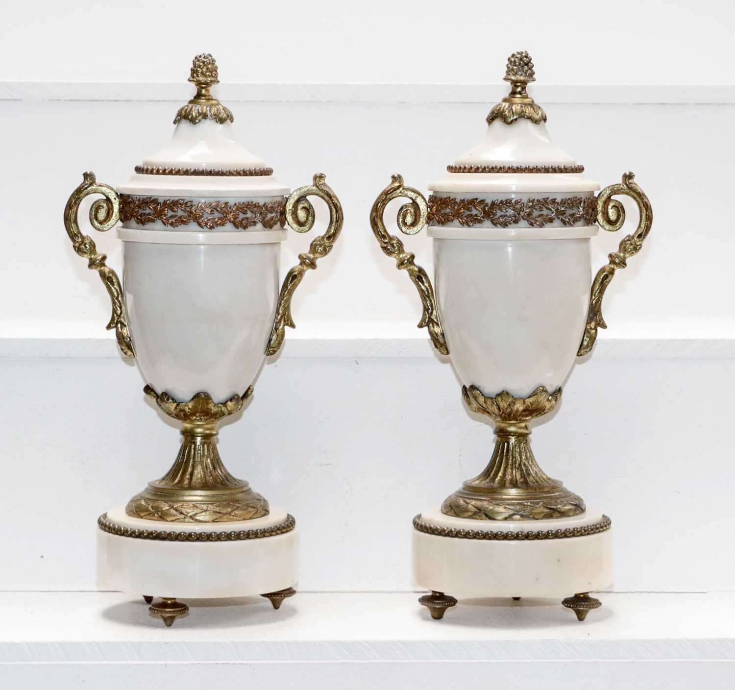 A pair of early 20th century white marble and gilt metal mounted garniture urns