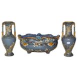 A Mettlach garniture comprising a twin handled centrepiece and a pair of vases, 34.5cm ground in