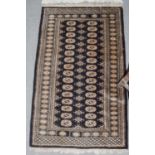 Pakistani Bukhara rug, the ivory field with areas of guls enclosed by multiple borders, 153cm by