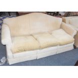 A modern cream upholstered humpback three seater sofa