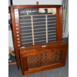 An early 20th century mahogany key cupboard and wall mounted chalkboard