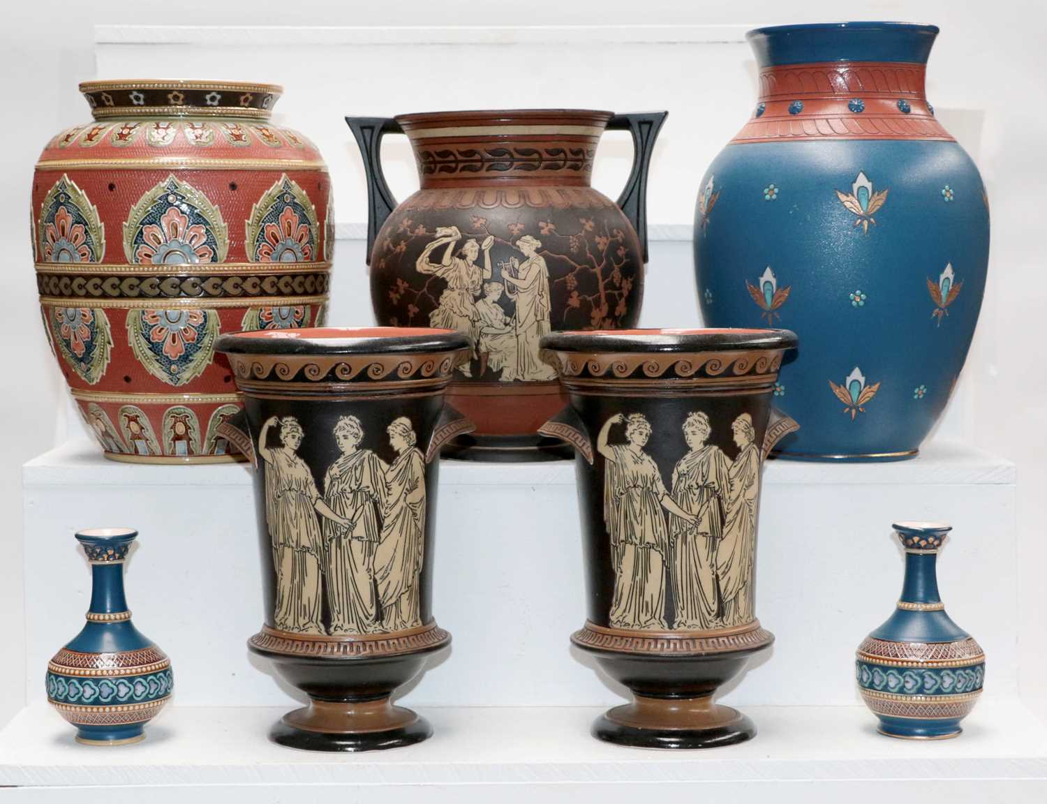 A quantity of Mettlach pottery including a garniture of three vases incised with Grecian figures,