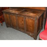 An 18th century oak four panelled coffer with carved scrollwork and foliate bands (alterations),