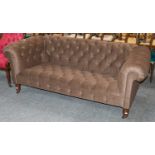 A brown upholstered Chesterfield style sofa