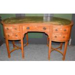 An Edwardian satinwood reniform writing table with gilt tooled leather inset top, 139cm by 68cm by