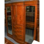 An Edwardian satinwood breakfront triple wardrobe by Maple & Co., the bowed centre section fitted