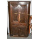 A George III oak freestanding corner cupboard