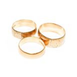 A 22 carat gold band ring, finger size Q; and two 18 carat gold textured band rings, out of