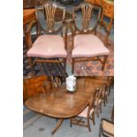 A 20th century Regency style crossbanded mahogany twin pillar dining table with additional leaf,