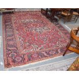 A Heriz carpet, the blood red field with flower head medallion framed by spandrels and indigo