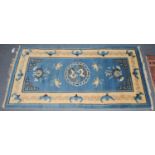 A Chinese rug, the sky blue field with central roundel enclosed by ivory borders, 180cm by 91cm;