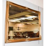 A large 20th century gilt framed wall mirror with bevelled glass, 135cm by 104cm