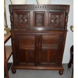 A 17th century oak court cupboard with foliate carved panel doors and turned supports (with