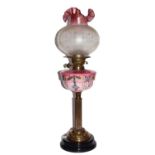 A Victorian oil lamp with reservoir, decorated with floral work