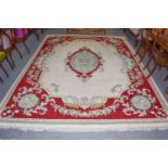 Indian 'Savonnerie' Carpet, the cream field with an oval medallion framed by blood red borders,