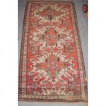 A Cheleberd rug, the brick red field with three 'eagle' medallions, enclosed by narrow ivory borders