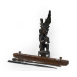 An African tribal carved hardwood statue of a seated figure wearing a headdress, two souvenir