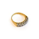 An 18 carat gold diamond six stone ring, the round brilliant cut diamonds in white claw settings, to