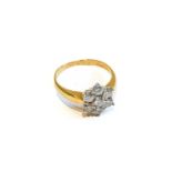 A diamond cluster ring, the round brilliant cut diamond within a border of further round brilliant