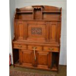 An early 20th-century oak cabinet, with shelves and recesses over a fall front, flanked by