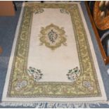 An Indian rug of Savonnerie design, a plain ivory field with scrolled central medallion, enclosed by