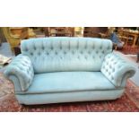 A button and blue upholstered sofa