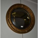 A Regency gilt framed convex mirror with ebonized slip