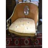 A 1920s/30s Bergere chair, double caned and with bamboo frame, the arms with swan head silvered