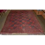 A Turkmen carpet, the madder field of elephant güls enclosed by stellar motifs, 306cm by 240cm