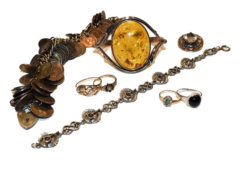 A collection of jewellery including an amber bangle, two 9 carat gold cluster rings (a.f.), two