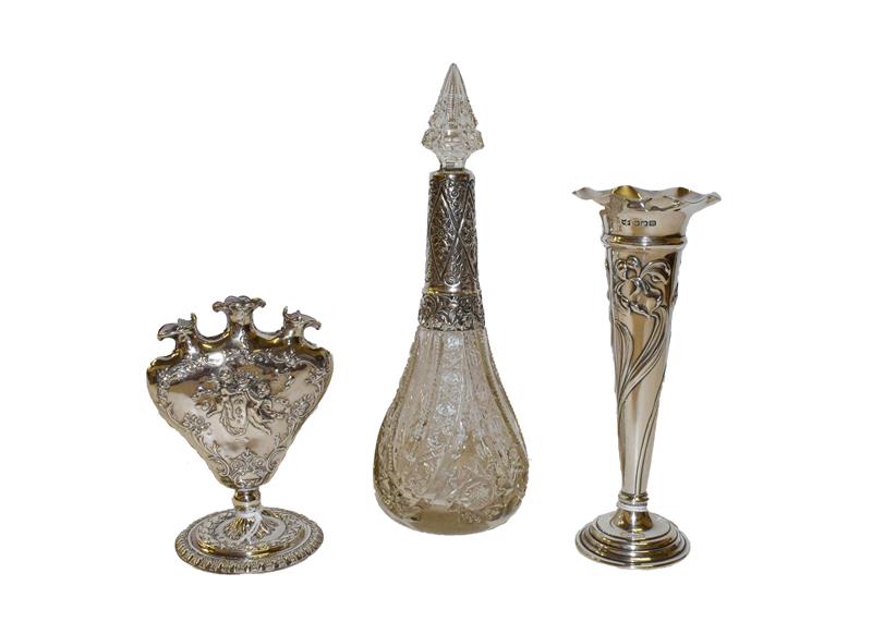 Two silver vases and a silver-mounted glass bottle, one vase by Mappin and Webb, Sheffield 1904,