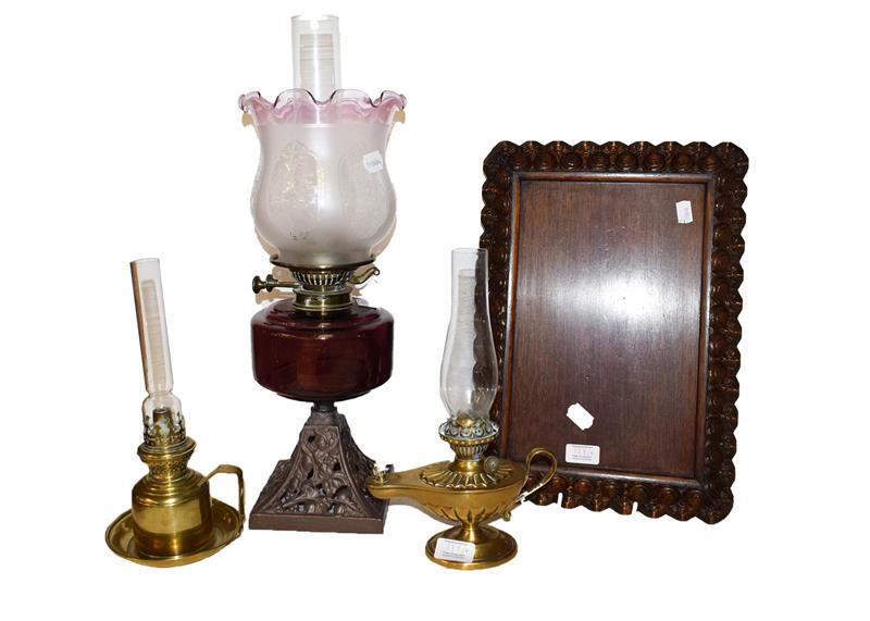 A carved oak serving tray, two Victorian brass based chamber lamps and an oil lamp with amethyst