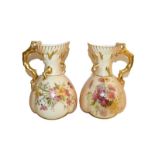 A pair of Royal Worcester ewers date code 1899, painted with flowers to a blush ground with gilt