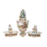 A pair of 19th century Dresden figural sweetmeat dishes raised on Rococo scroll bases together