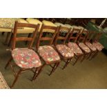 A set of eight early 20th century mahogany kitchen chairs raised on turned supports with squab