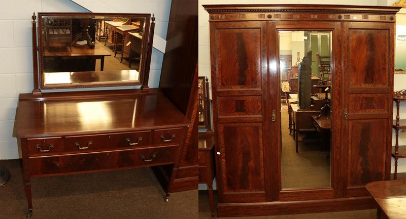An Edwardian mahogany mirror fronted triple wardrobe, crossbanded and with egg and dart mouldings,