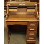 An early 20th century oak roll top desk of small proportions, 91cm by 68cm by 119cm