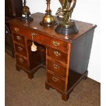 A George II oak kneehole dressing table, the moulded top above a frieze drawer flanked by six