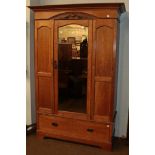 An Edwardian oak mirror front single door wardrobe, 130cm by 46cm by 208cm